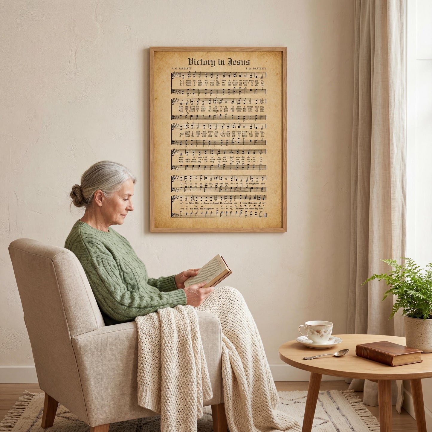 An elderly woman is sitting in a chair, reading a book, with a framed sheet music poster of "Victory in Jesus" hanging on the wall behind her.
