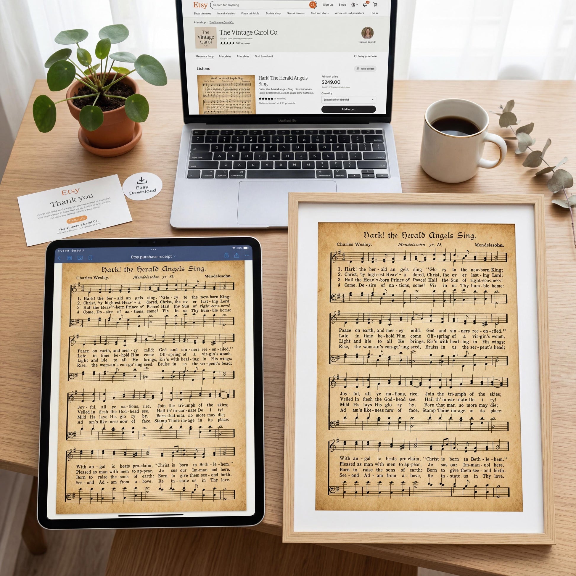 a wooden desk with various items on it, including a laptop, a framed sheet of music, a potted plant, and a cup of coffee.