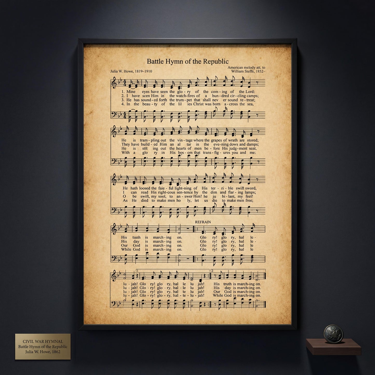 The image is a framed print of the Battle Hymn of the Republic, a hymn composed by Julia W. Hoever in 1819. The hymn is displayed on a dark wall, and there is a small plaque below it that reads "CIVIL WAR Hymnal JULIA W. HOEVER 1862".