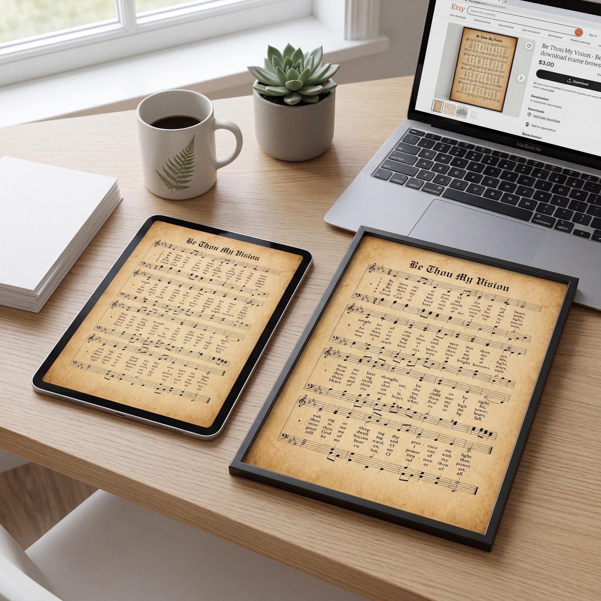a wooden desk with various items on it, including a laptop, a framed sheet music print, a coffee cup, a potted plant, and some books.