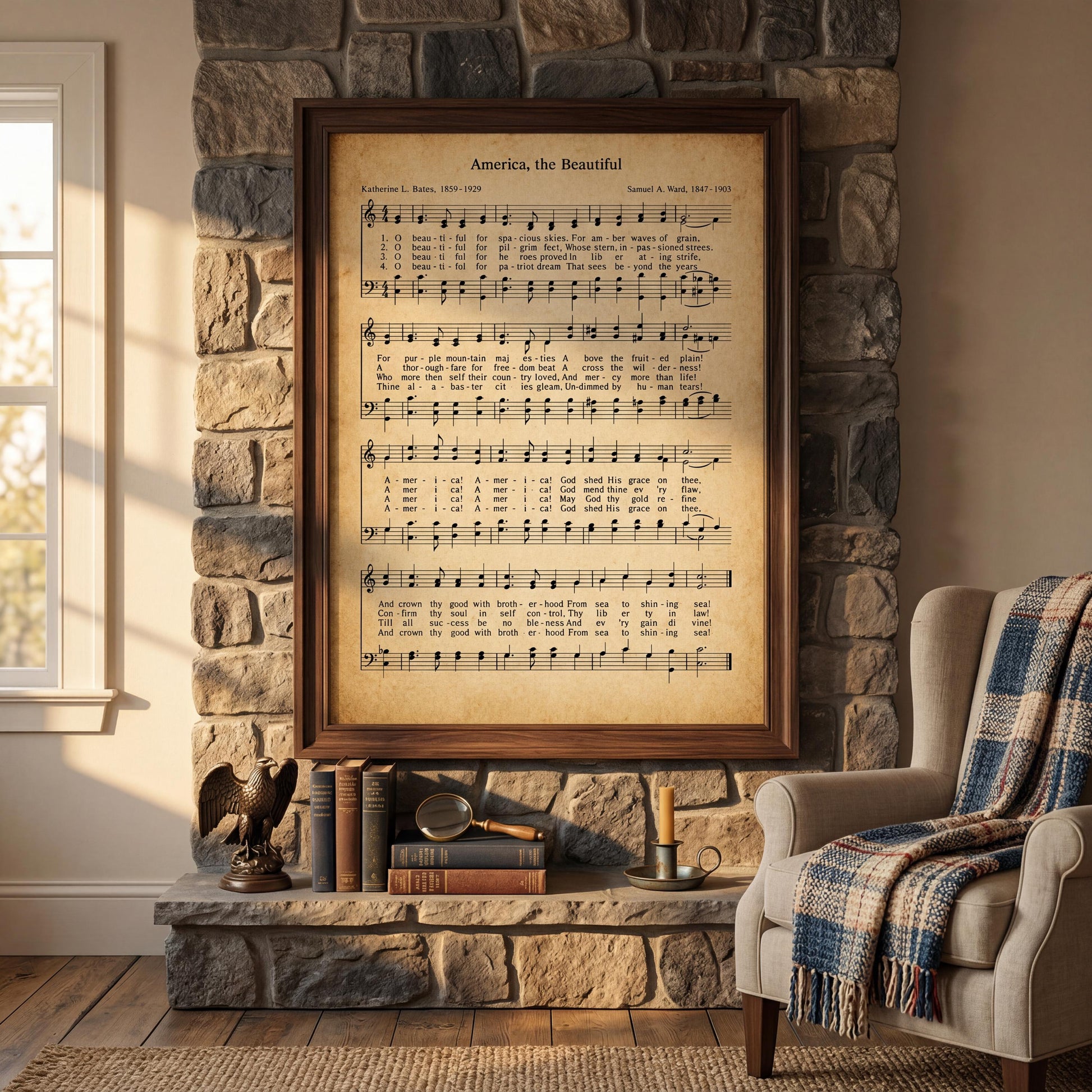 a framed sheet music poster of "America the Beautiful" by Samuel L. Bate, displayed on a stone fireplace mantel. The mantel is adorned with various books, a magnifying glass, and a plaid blanket. A beige armchair is positioned in the foreground, and a window can be seen in the background.