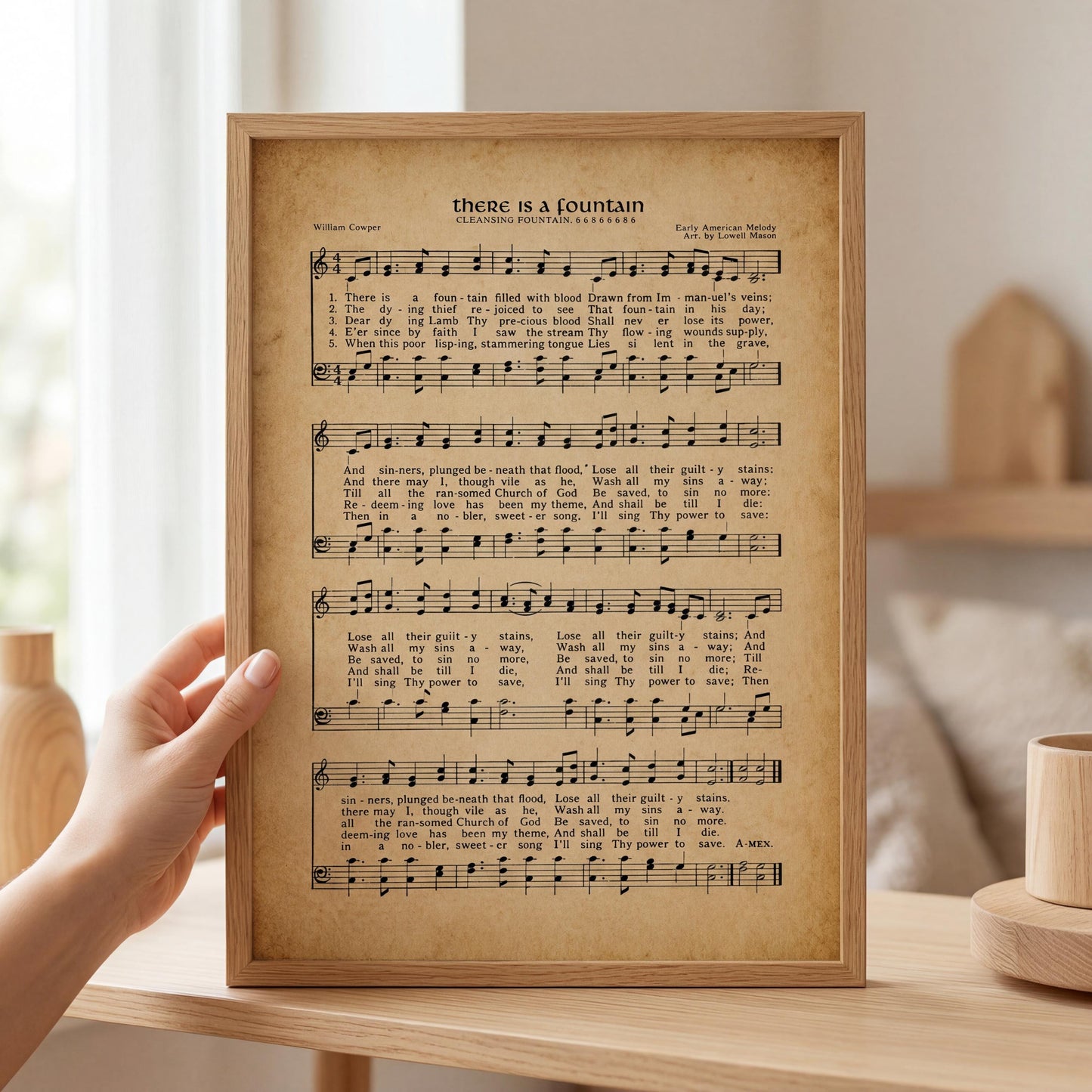 A person is holding a framed sheet of music with lyrics and musical notation, which appears to be a hymn or song.