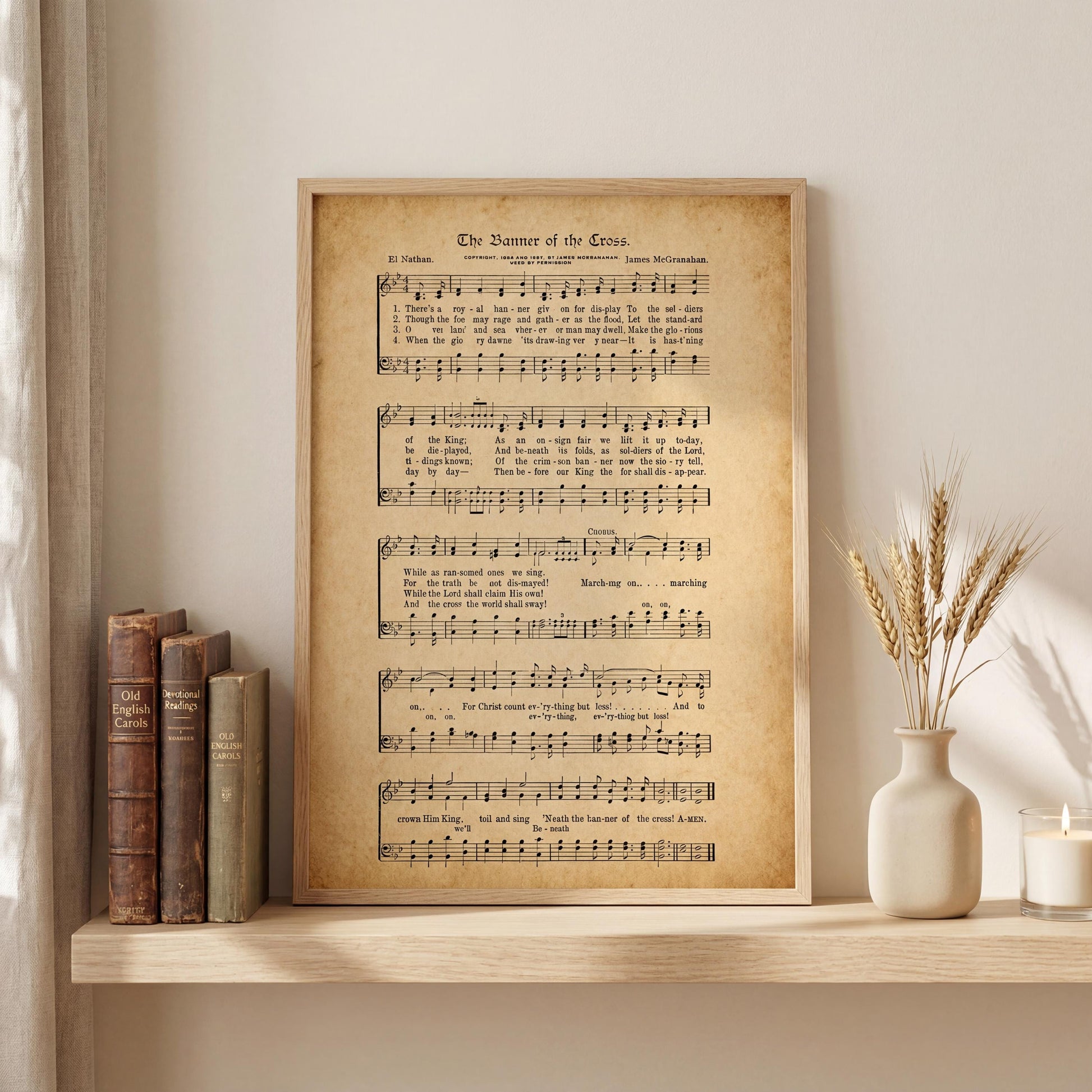 a framed sheet of music titled "The Banner of the Cross" with a vintage, old-fashioned appearance. The sheet music is displayed on a shelf next to a vase with wheat stalks and a few books.