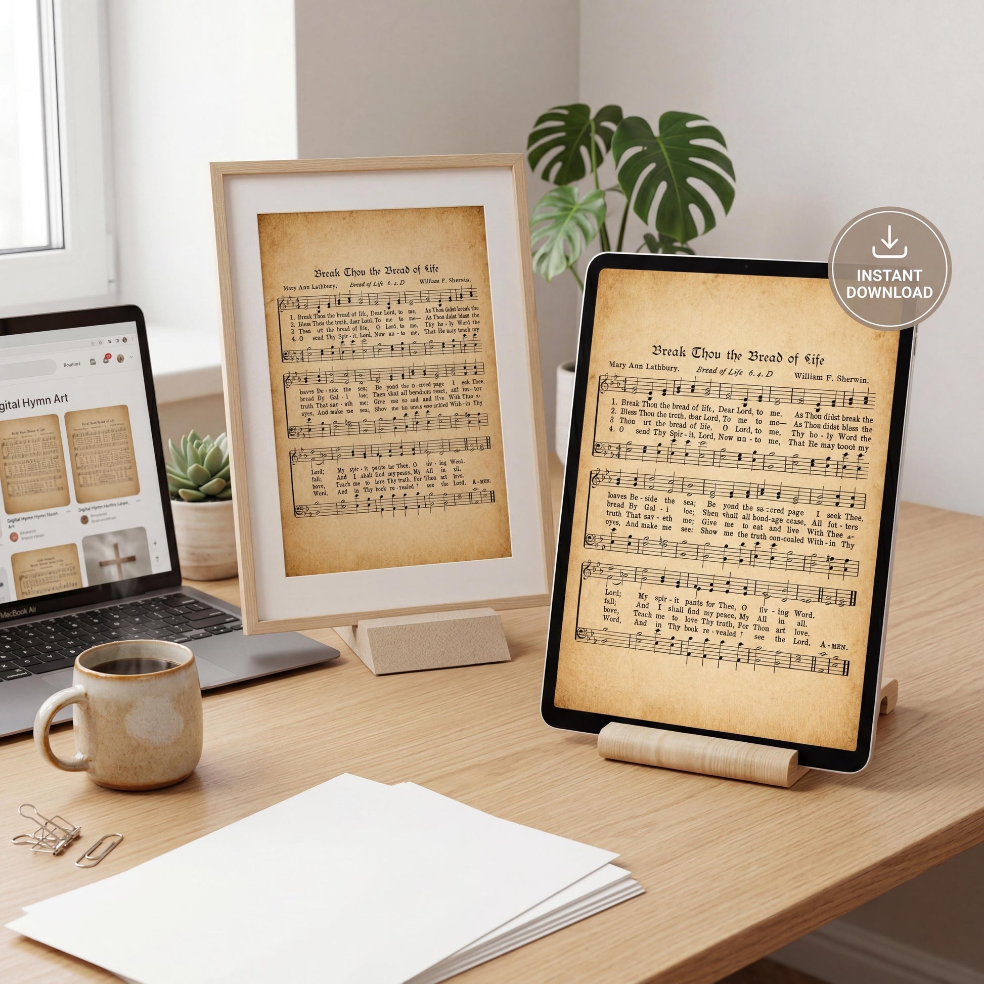 a wooden desk with a laptop, a framed print of sheet music, a tablet displaying sheet music, and a mug of coffee. There is also a potted plant and a laptop computer in the background.