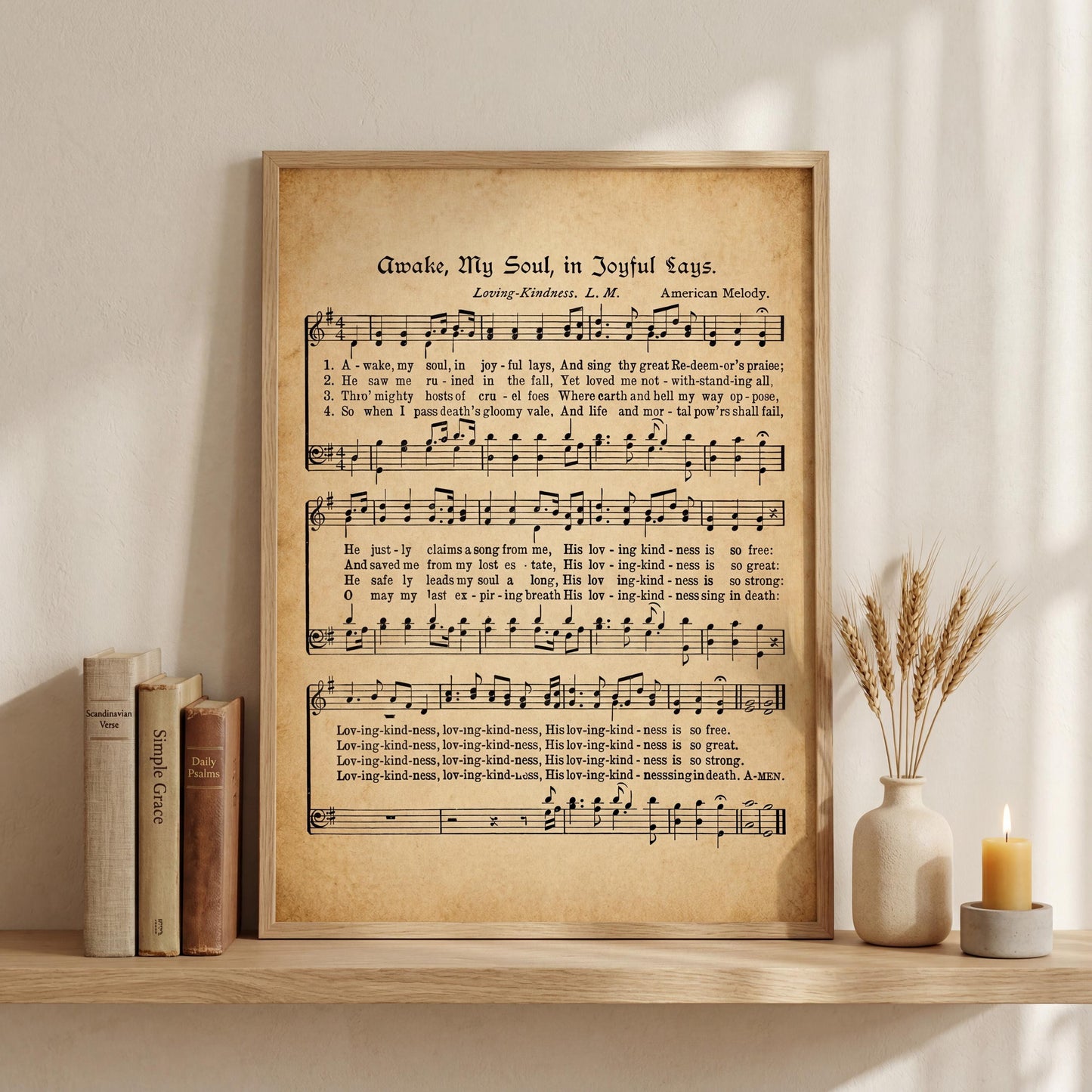 a framed sheet music poster of a hymn titled "A Wake-Up Song in Joyful Days" by Loring-Kente, accompanied by a vase of wheat stalks and a lit candle on a shelf.