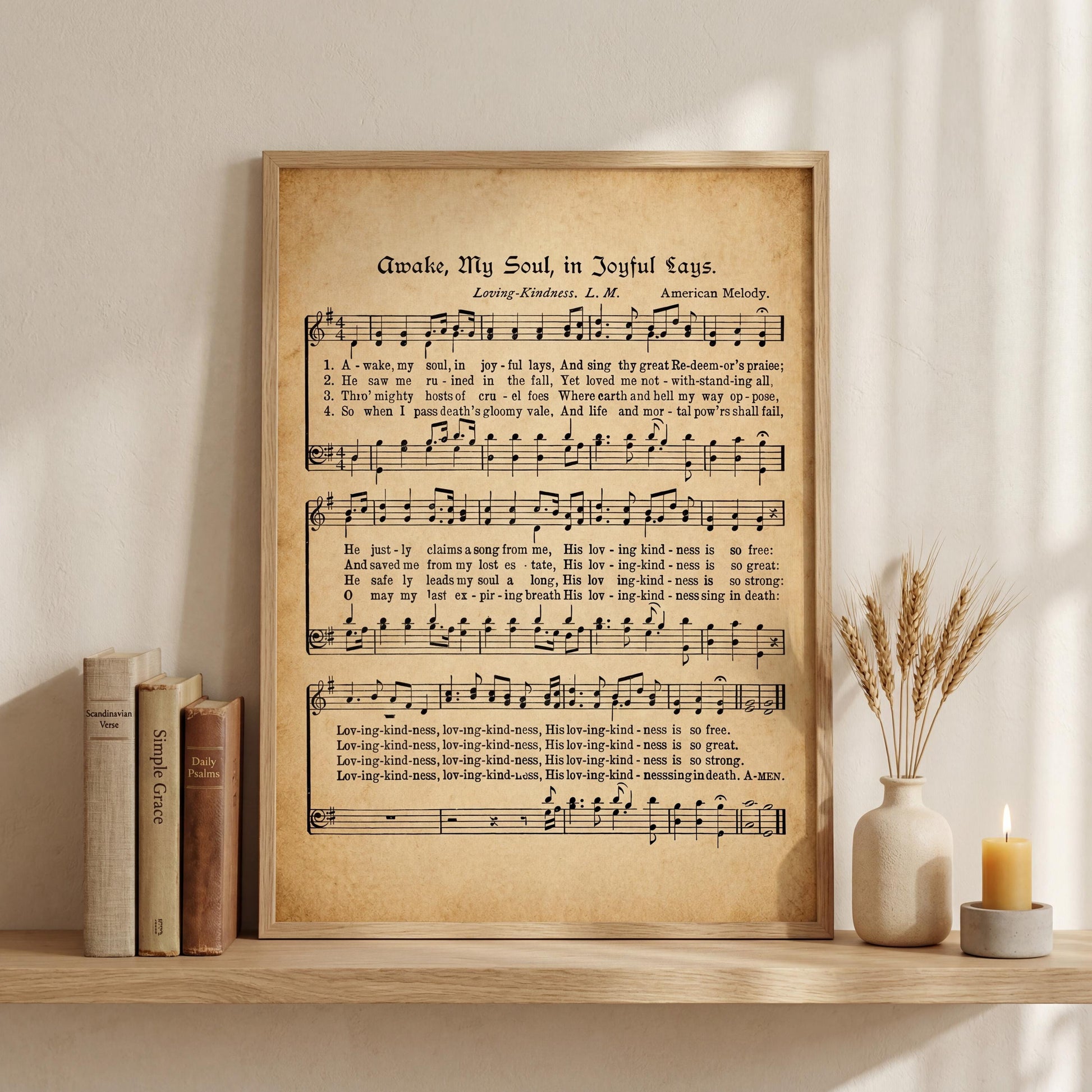 a framed sheet music poster of a hymn titled "A Wake-Up Song in Joyful Days" by Loring-Kente, accompanied by a vase of wheat stalks and a lit candle on a shelf.