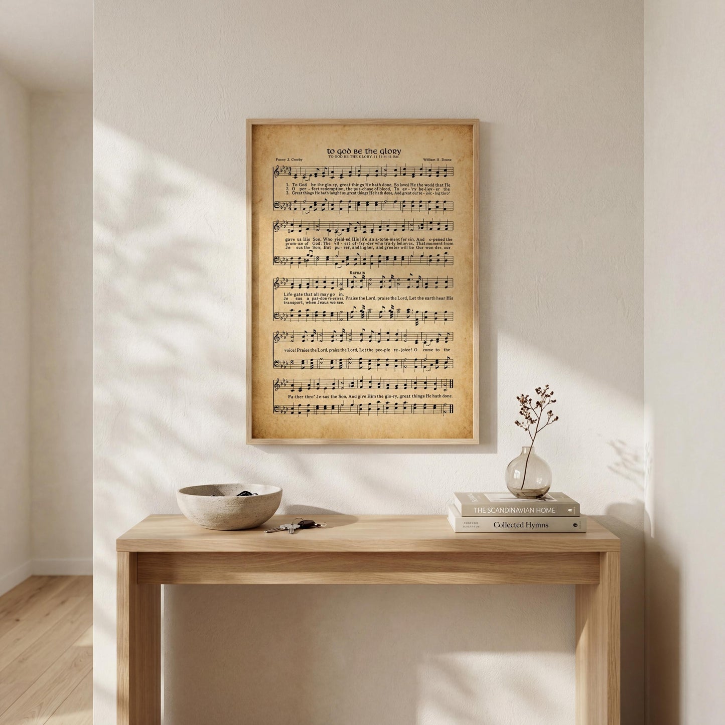 a wooden table with a bowl and a vase on it, along with a framed sheet music poster hanging on the wall above it.
