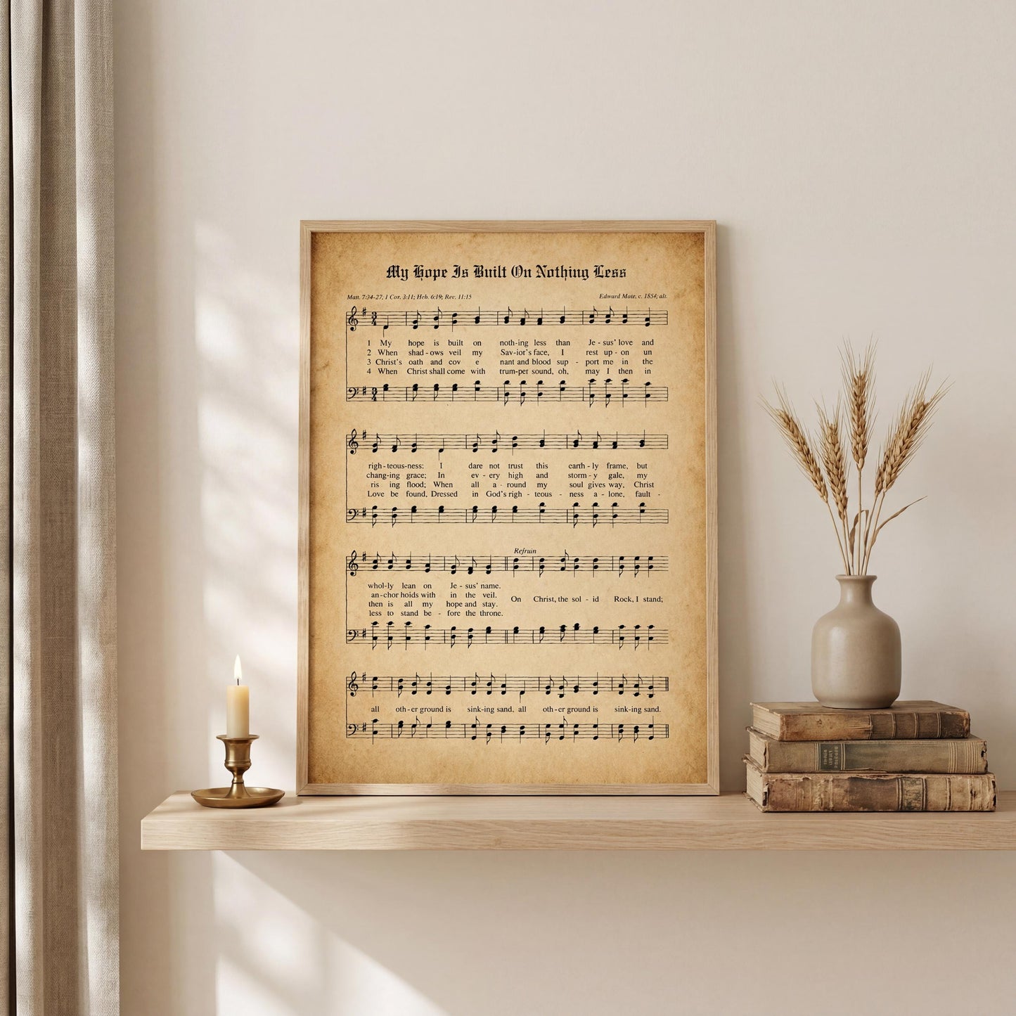 a framed sheet music with lyrics, a lit candle on a shelf, and a vase of wheat stalks.