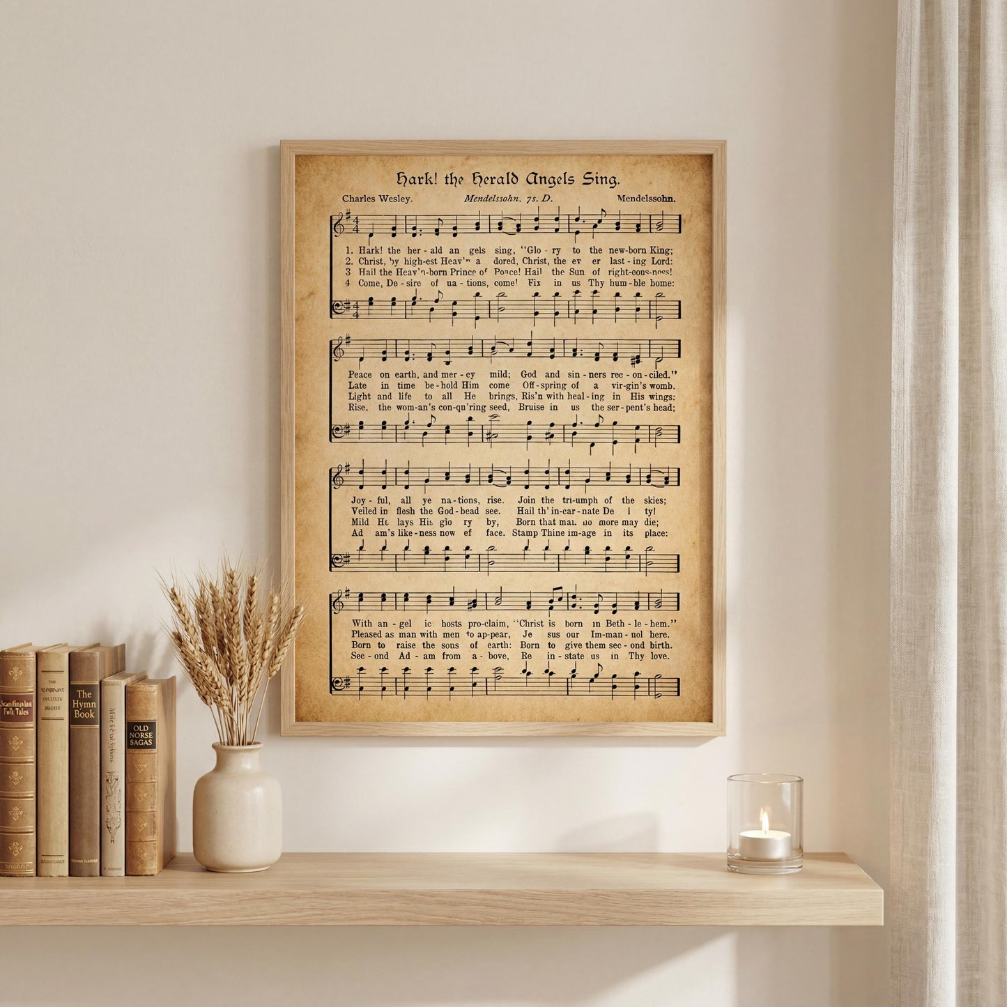 a framed sheet music poster of "The Holy Angels Sing" displayed on a wall above a wooden shelf with books and a vase of wheat stalks.