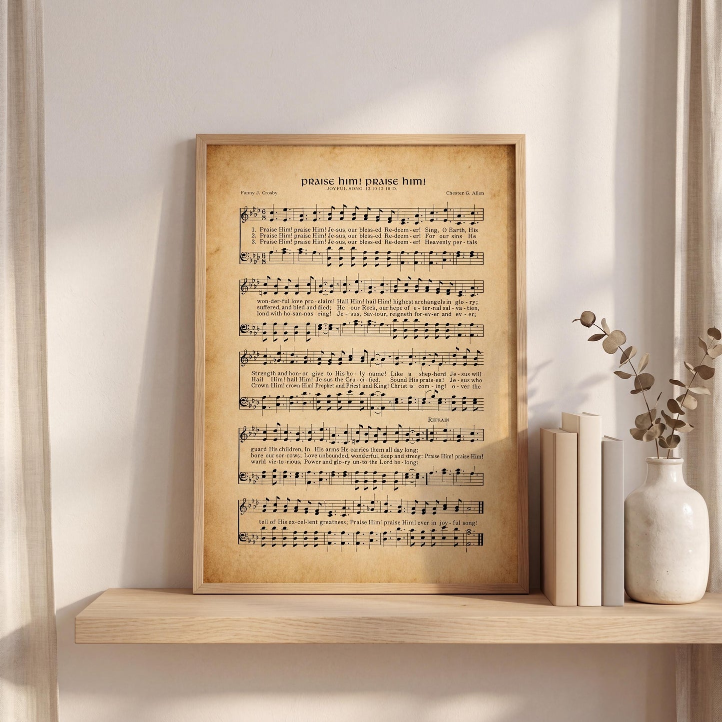 a framed sheet of music with the title "Pray, praise, praise him" on it, placed on a shelf next to a vase with dried flowers.