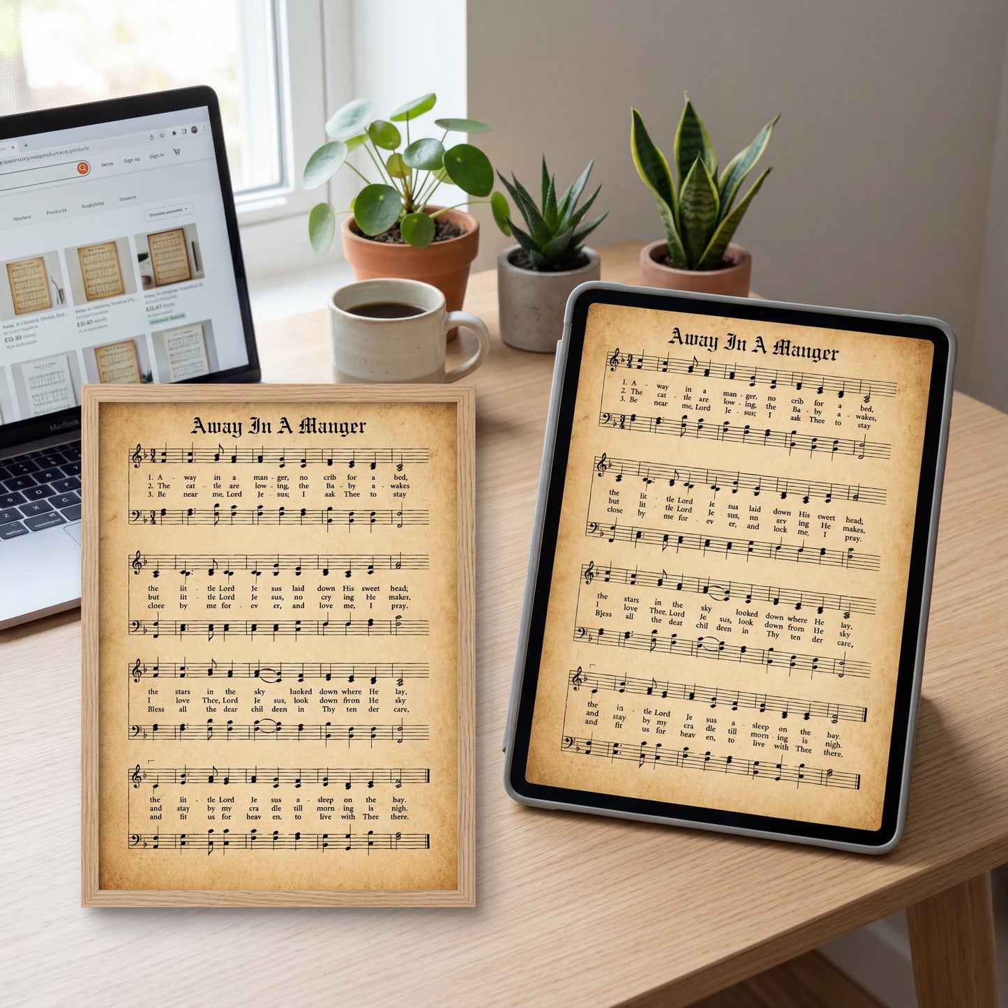 a wooden desk with a laptop, a framed sheet of music titled "Away in a Manger" and a tablet displaying the same sheet music. There are also potted plants and a cup on the desk.