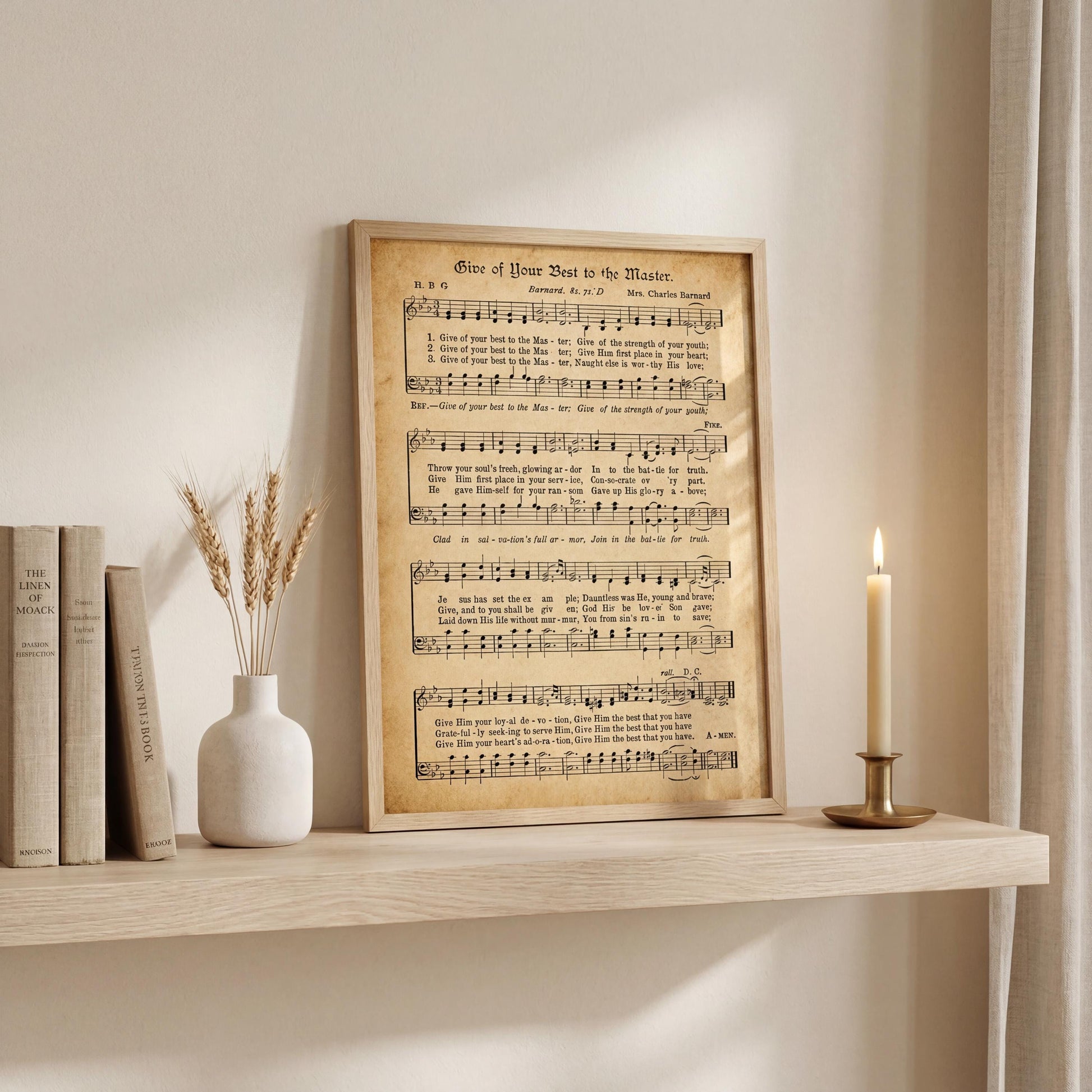 a framed sheet music poster of a hymn, a white vase with wheat stalks, and a lit candle on a shelf.