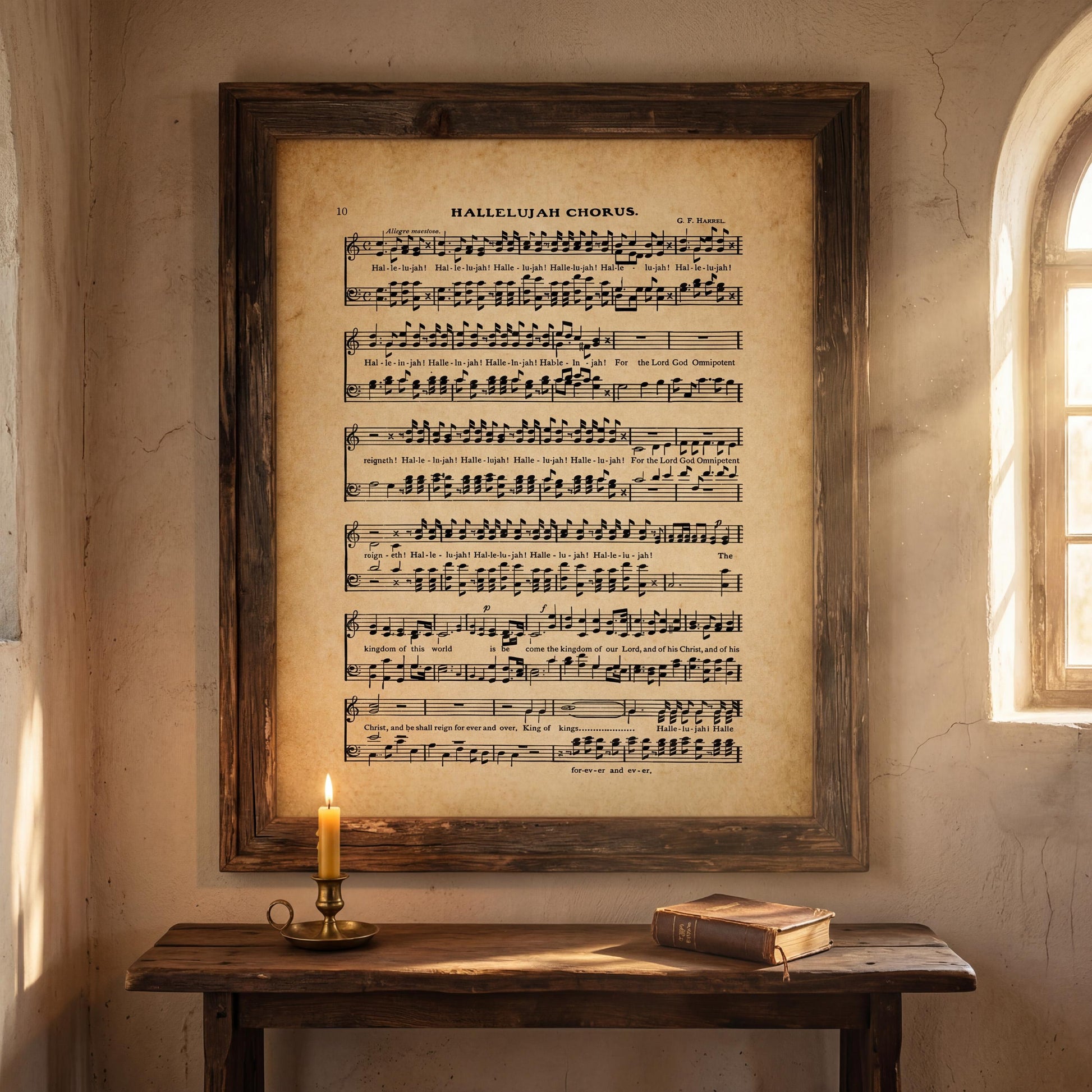 a wooden table with a lit candle, a book, and a framed sheet music poster hanging on the wall above it.