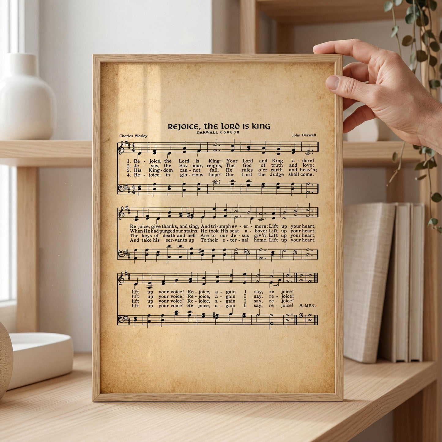 A framed sheet of music titled "Rejoice, the Lord is king" by John Davidow, with a hand holding it up.